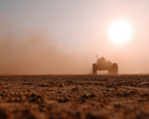 Sandstorm sweeps across barren field, with vehicle silhouetted against bright sun. scene captures raw power of nature and resilience of machinery in challenging conditions
