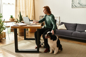 Young man enjoys a cozy afternoon at home with his loyal dog by his side while working