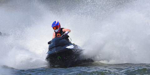 Jet Ski racer cornering at speed creating at lot of spray