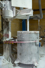 Paint production workshop. In a large industrial container, components of acrylic paint are being...