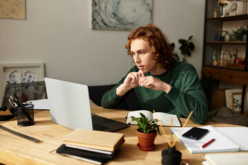Young man deeply focused on his laptop while working from the comfort of his home setting