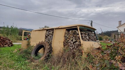 Vergessenes Auto-Wrack – Rostiges Chassis als Holzlager auf Feld