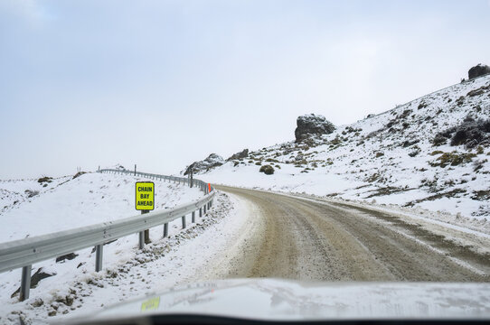 CHAIN BAY AHEAD road sign on a frozen snow mountain road. Wanaka. Otago Region. South Island.