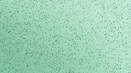Fototapeta premium Close-up of a textured surface with a light green color. the surface appears to be made up of small, irregularly shaped particles that are scattered randomly across the image.