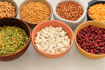 Variety of protein products for vegetarians. Soy, lentils, peas, chickpeas and various types of beans in bowls. Top view. Place for text.