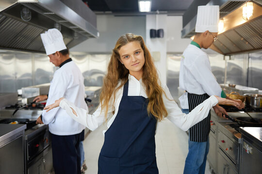 portrait young woman chef showing pose in the kitchen