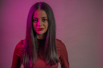 Fototapeta premium Fashion model posing with creative magenta lighting and red lipstick
