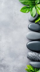 Obraz premium Zen Harmony: A serene arrangement of smooth stones and vibrant green leaves evokes tranquility and relaxation, a perfect visual metaphor for balance and well-being.