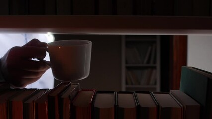 Librarian taking a coffee break in the library surrounded by books - Powered by Adobe