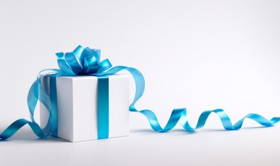 A white gift box with a shiny blue ribbon next to curled gold ribbons.