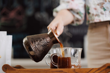 Caucasian female preparing fresh coffee in traditional turkish pot