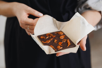 Thai Asian Dark chocolate with dried shrimps held by caucasian female adult