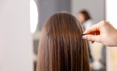 Fototapeta premium Female client receiving hairpin styling in modern salon setting
