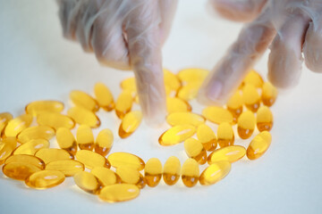 Top view Quality control in medical production: worker inspects omega 3 capsules
