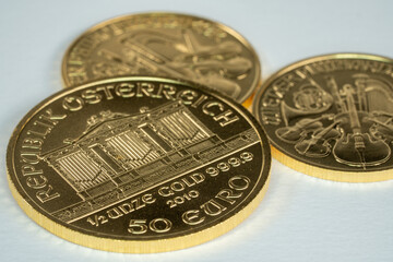 Three gold ounce coins Krugerrand Wiener Philharmoniker pure gold on white surface 2