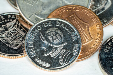 Half Balboa Republic of Panama coin with one US Dollar cent and other coins in background
