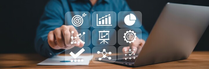 Person interacting with a holographic display of business icons on a laptop.