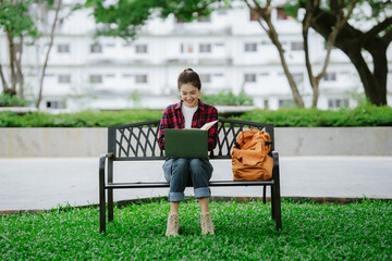 Fototapeta premium Young asian woman relaxing reading book sitting at public park life style outdoor. Happy female Take a break enjoy time living in the nature. Human and nature together