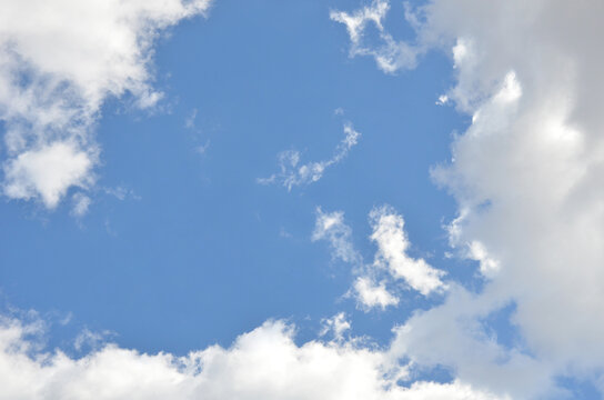 Bright blue sky landscape in sunny day clearn in the middle with white border of white fluffy clouds .Nature , environment, sky background, concept.