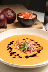 Vertical image of salmorejo, cold tomato soup, served with iberico jam.