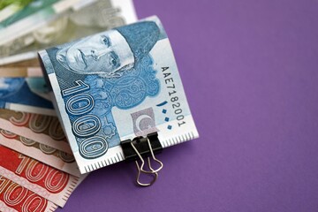 Pakistan rupees banknotes on purple background. The current Pakistan money bills lies on table in big amount. The concept of business and investment in Pakistan