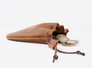 natural leather cow hide pig skin coin purse with draw cords  and loose coins isolated on a white background