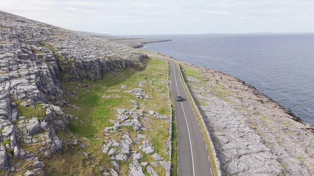 A winding road along the rocky coastline of the burren in ireland, aerial view