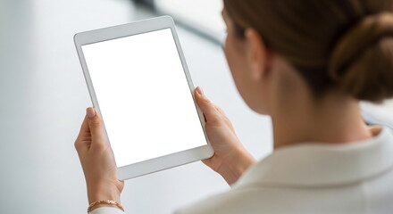 Woman holding a white digital tablet with a blank screen. Female user interacting with technology. Mockup for presentation or advertisement.