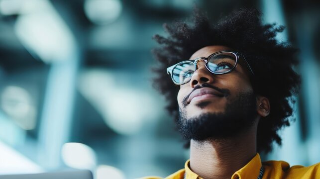 A focused young man gazes thoughtfully into the distance, capturing a moment of introspection and ambition, set against a modern, blurred background in a professional environment.