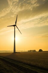 Obraz premium At sunset, a towering wind turbine casts a dramatic silhouette against a golden sky, framed by distant turbines and verdant fields