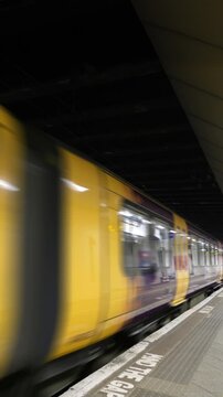 Train moving past a platform loop.
Never-ending train going past a platform in a station. Vertical format. Loops.