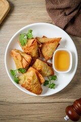 Samosas in a white plate on wooden background ,indian fried samosa, indian snack