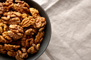 Raw Walnut Halfs in a Bowl, top view. Flat lay, overhead. Copy space.