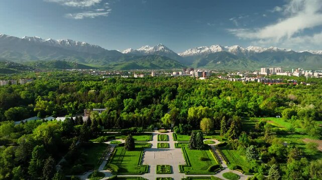 Aerial view panorama of green park against mountains in city Almaty