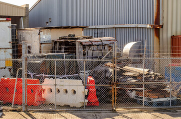 An industrial junkyard or weathered corrugated steel shed featuring a rusted, partially dismantled...