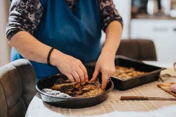 Elderly woman arranging food for preparation, showcasing cooking techniques and traditional methods, with warm tones conveying a sense of home, family, and culinary traditions.