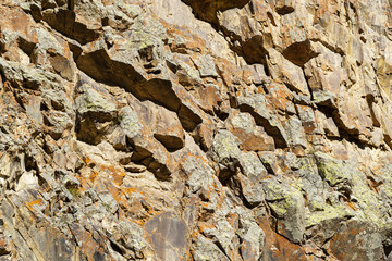 Rugged cliff face with layered rocks and patches of lichen, showcasing the raw, textured beauty of natural stone formations. Kabardino-Balkaria, Chegemsky district