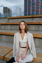 Confident businesswoman seated outdoors in professional attire, expressing determination and...