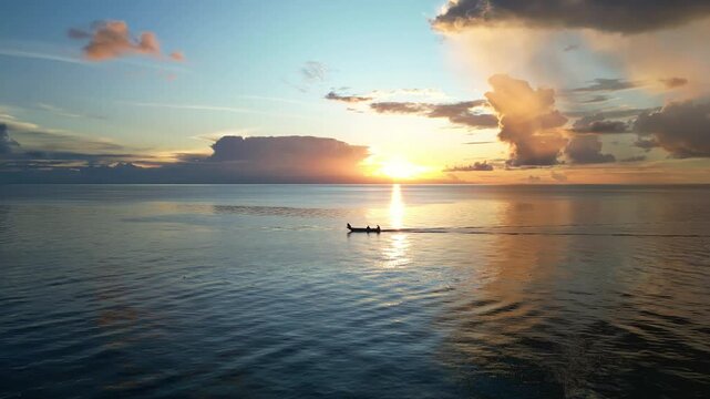 Maratua, Indonesia: Aerial drone footage of a local wooden boat sailing during sunset over the Celebes sea in the Maratua island in the Derawan archipelago in Borneo, Indonesia. 