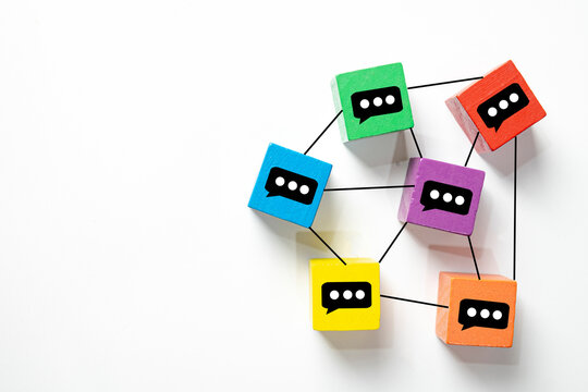 Colorful wooden blocks with chat bubble icons connected by lines. Concept for social media networking, online communication, community engagement.,White background with copy space.