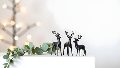 Black reindeer figurines placed near Christmas tree with lights  