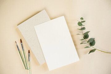 Quality art supplies arranged on a neutral background featuring watercolor brushes, paper blocks,...