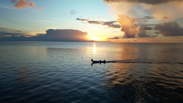 Maratua, Indonesia: Aerial drone footage of a local wooden boat sailing during sunset over the Celebes sea in the Maratua island in the Derawan archipelago in Borneo, Indonesia. 