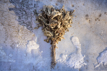 Close-Up of a Frozen Oak Bath Broom on Snow, Symbol of Hygiene and Wellness