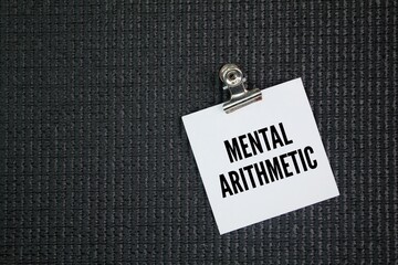 White paper with the word mental arithmetic. arithmetical calculations performed in the mind,...