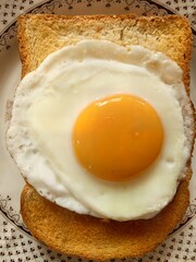 Perfectly fried egg with a bright yolk on a slice of toast