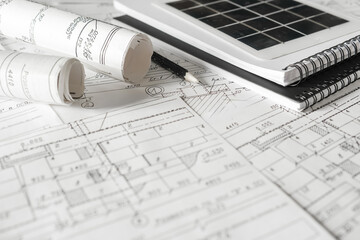 sustainable architecture tools and materials: blueprints, solar panel, wood textures, fabric swatches, and stones. Eco-friendly design, conscious construction and green innovation.	