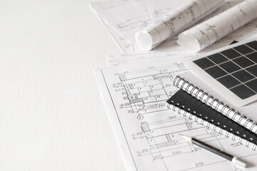 sustainable architecture tools and materials: blueprints, solar panel, wood textures, fabric swatches, and stones. Eco-friendly design, conscious construction and green innovation.	