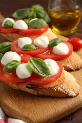 Tasty sandwiches with mozzarella cheese, tomatoes and basil on table, closeup