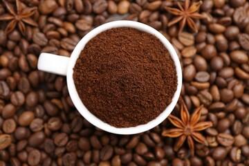 Cup with instant coffee powder and star anise on beans, top view